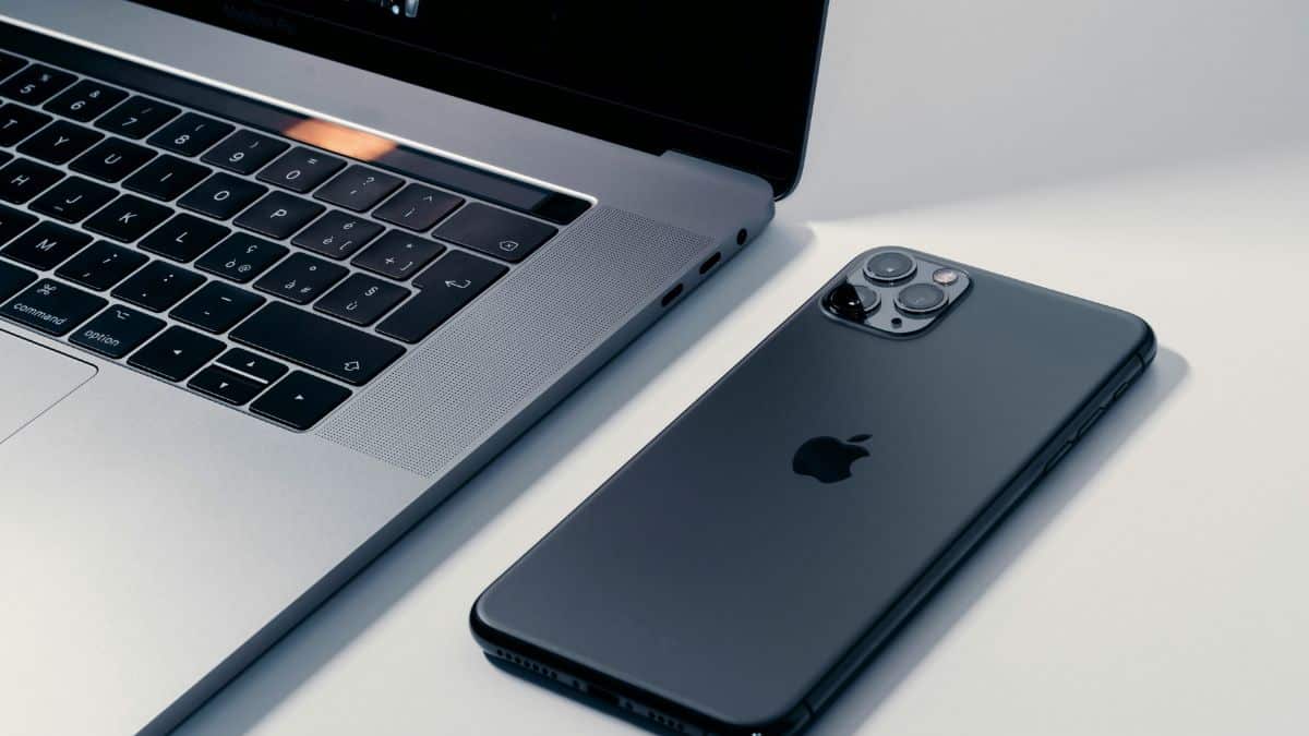 Mobile-First Design: 2026 Best Practices for Creating a Seamless User Experience 1 A Macbook Pro Laptop Next To A Space Gray Iphone 11 Pro On A White Surface, Representing Desktop And Mobile Web Browsing.
