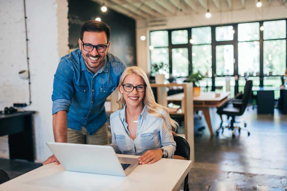 Two Small Business Professionals Working On Seo And Digital Marketing Strategy At A Laptop In A Modern Office.
